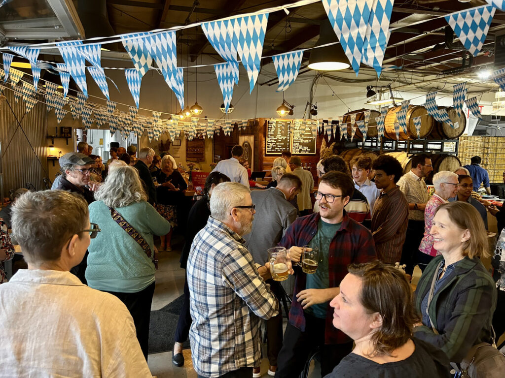 Investors and community members gather at Dominion City Brewing Company to celebrate reaching the Housing Forever Bonds campaign goal.